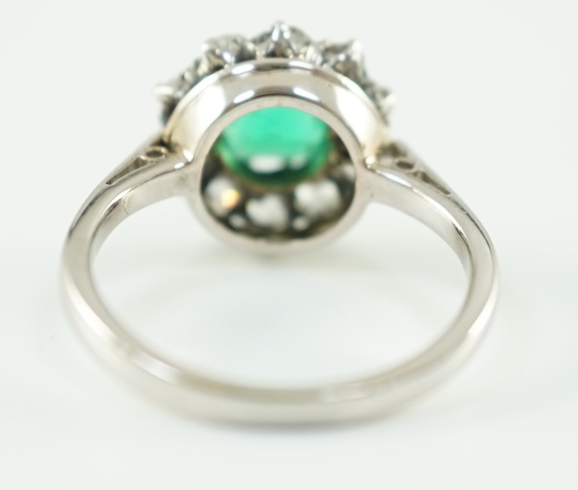 An early to mid 20th century, platinum, octagonal cut emerald and round cut diamond set circular cluster ring